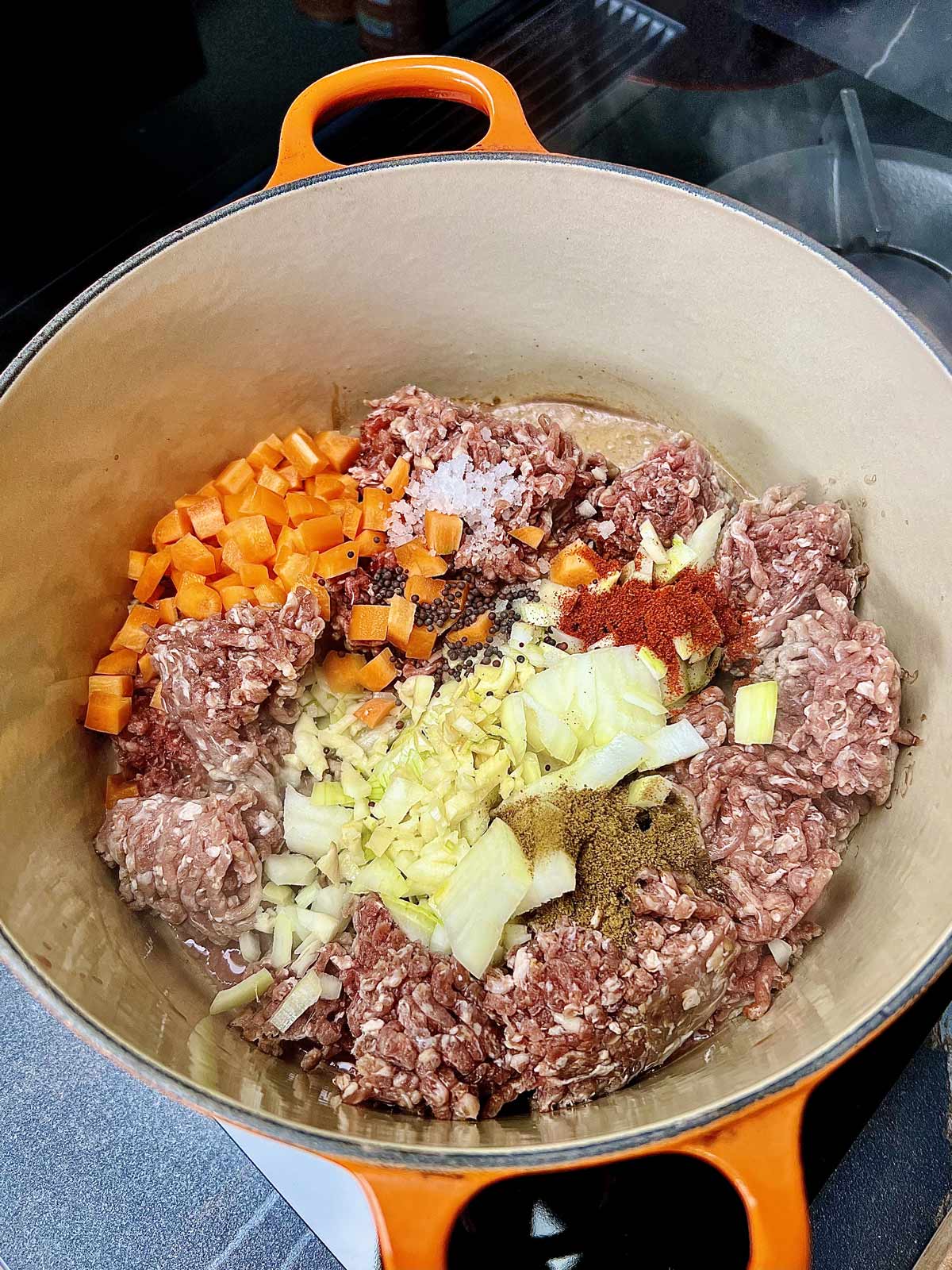Ground, beef, carrots, salt, garlic, onions, Cuman powder, client, pepper, powder, cooking in a pot for baked beans with ground beef.