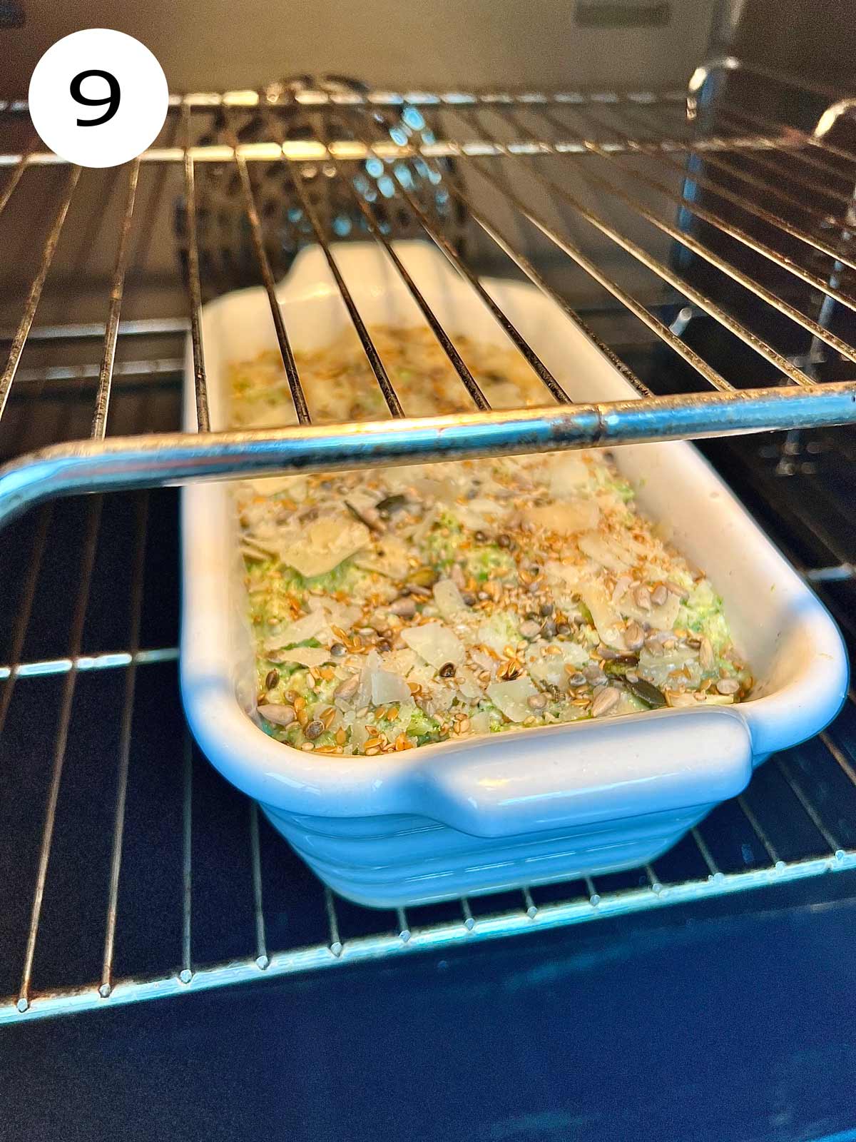 Broccoli and cheese bread in a white ceramic oven pro dish being placed in the oven.