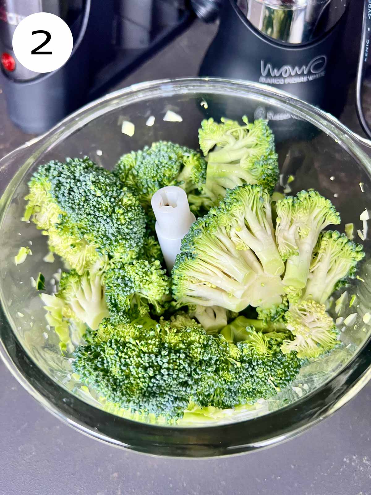 Broccoli florets in a glass blender.