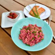 Butter bean hummus with beetroot on a greenplate.