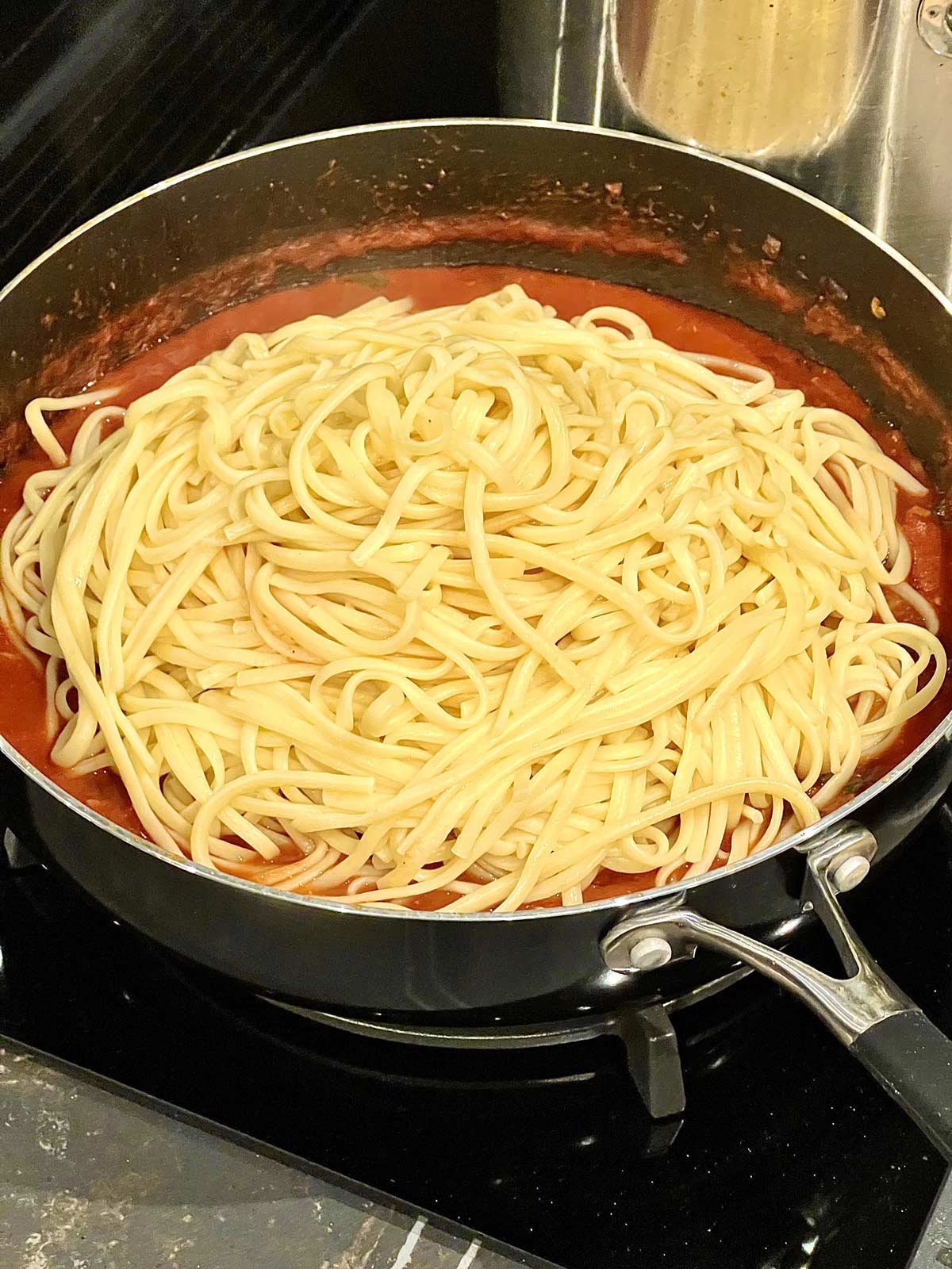 Cooked pasta added to the sauce for the prawn and chorizo linguine.