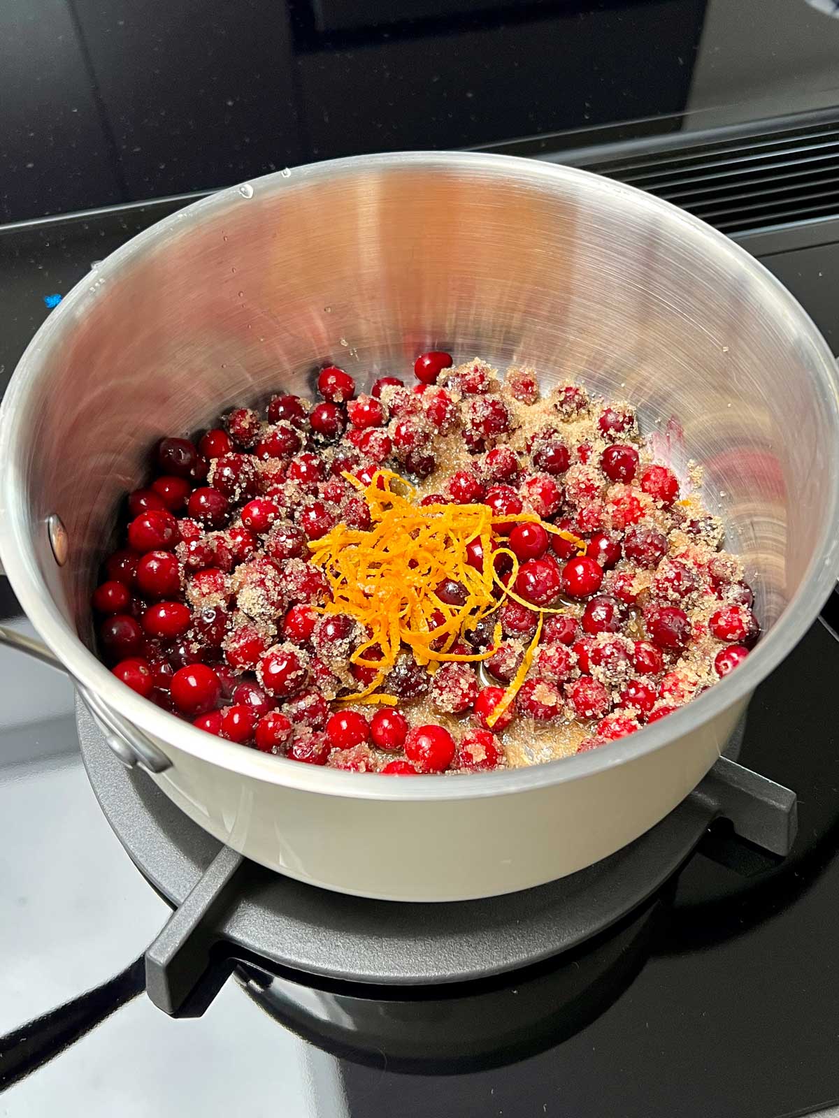 Cranberry mixed with sugar and lemon zest ready to be cooked.