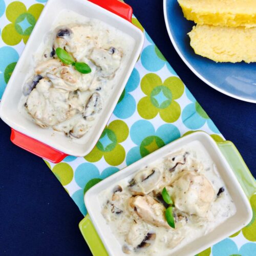 Creamy chicken and mushrooms with polenta, on a two rectangular serving dishes, birds view.