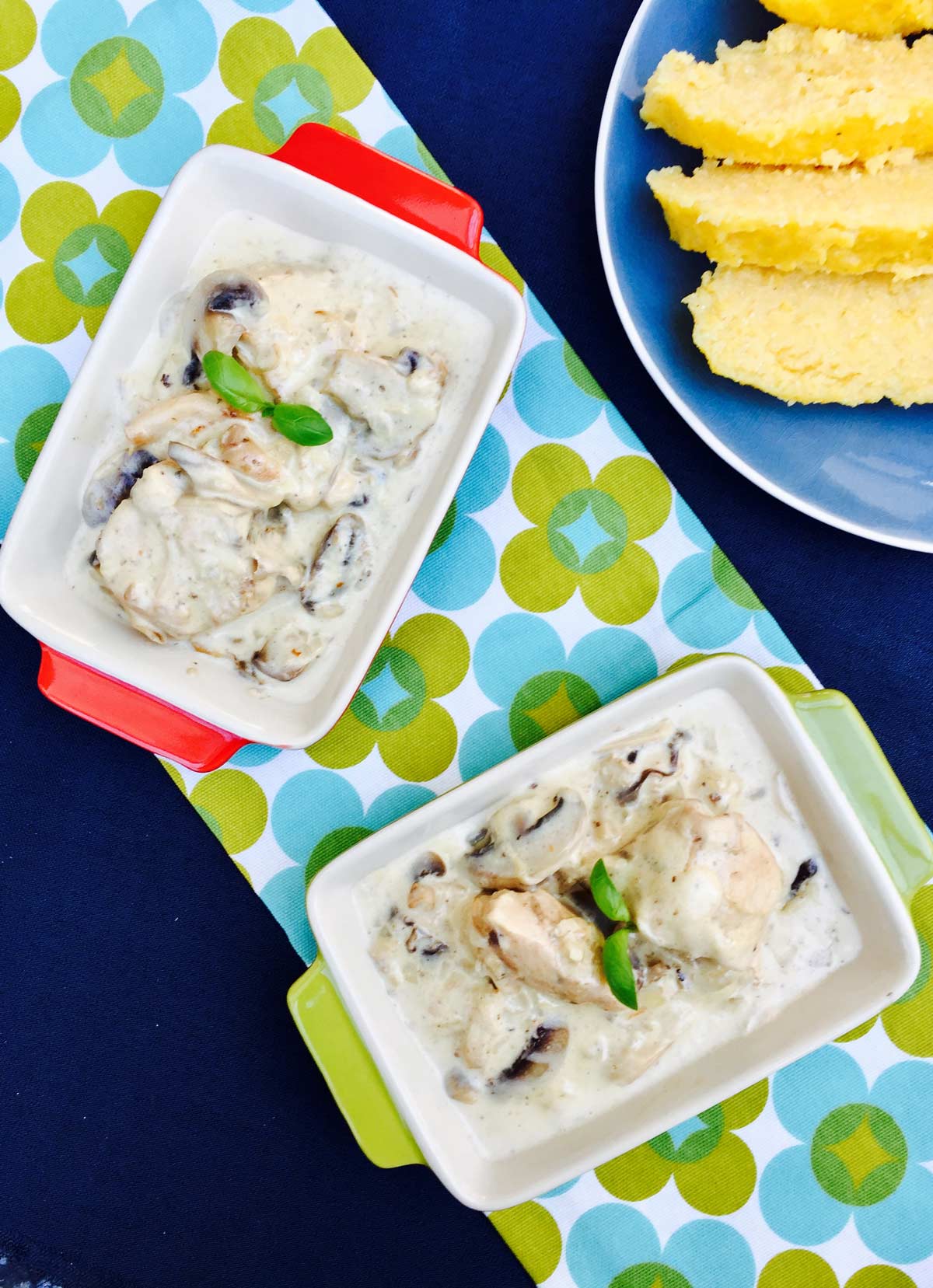 Creamy chicken and mushroom with polenta, on a two rectangular serving dishes, birds eye view.