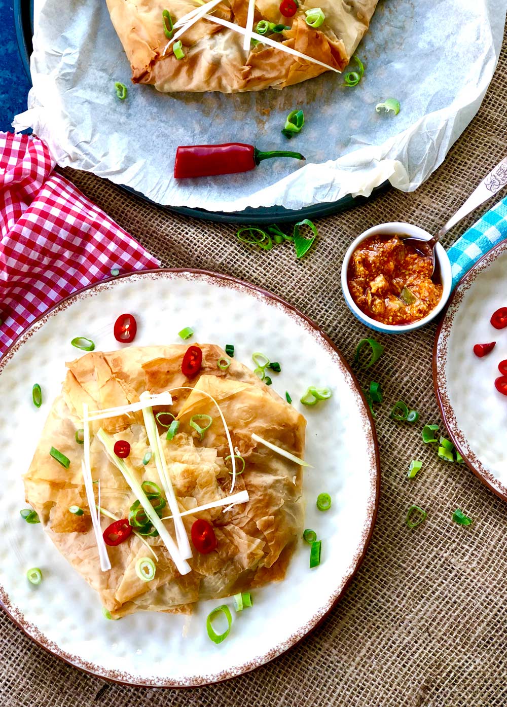 Birds eye view of a whole baked Giant potato and cauliflower filo samosa pie on a plate