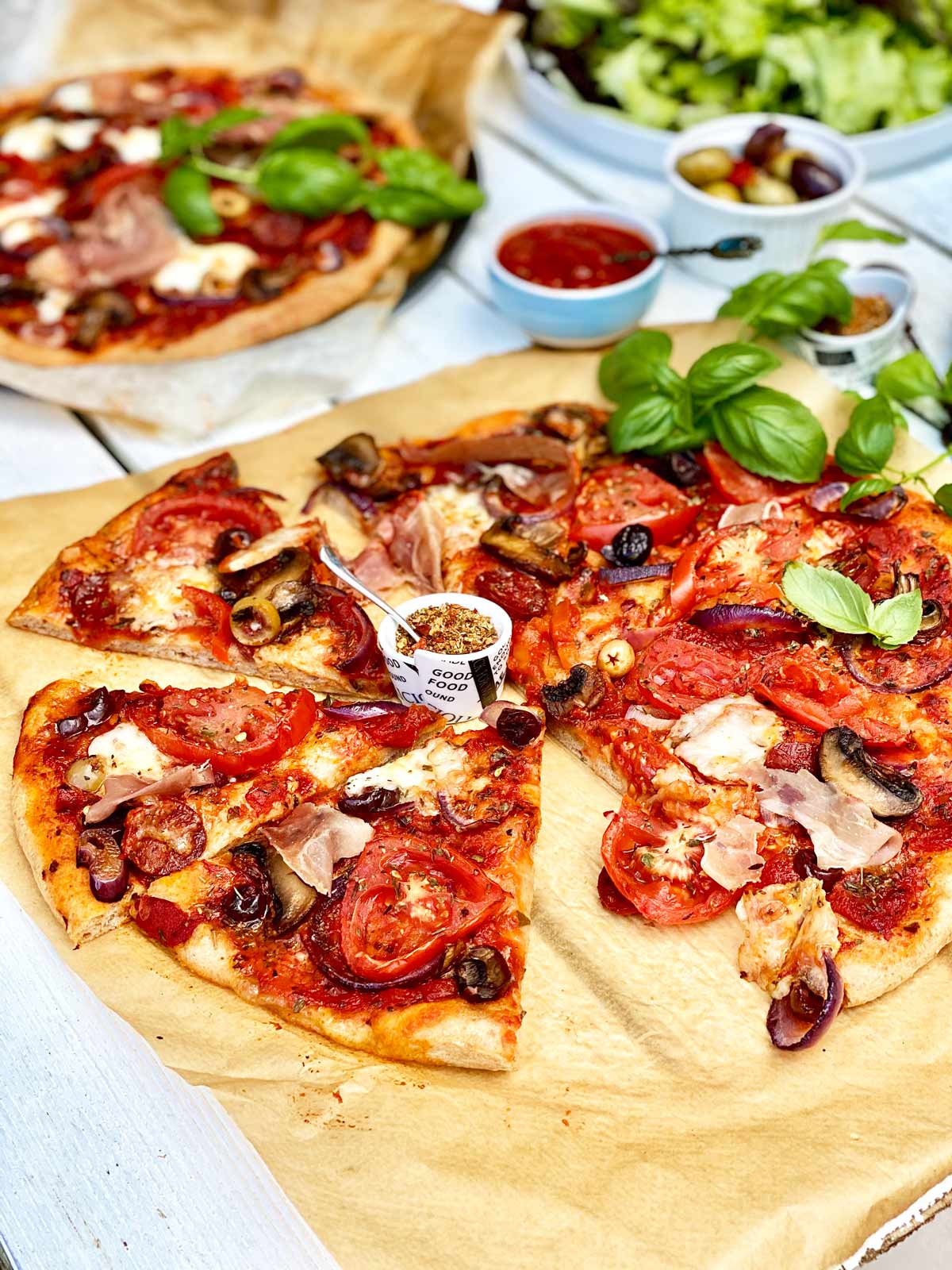 Homemade pizza on brown parchment paper without a slice