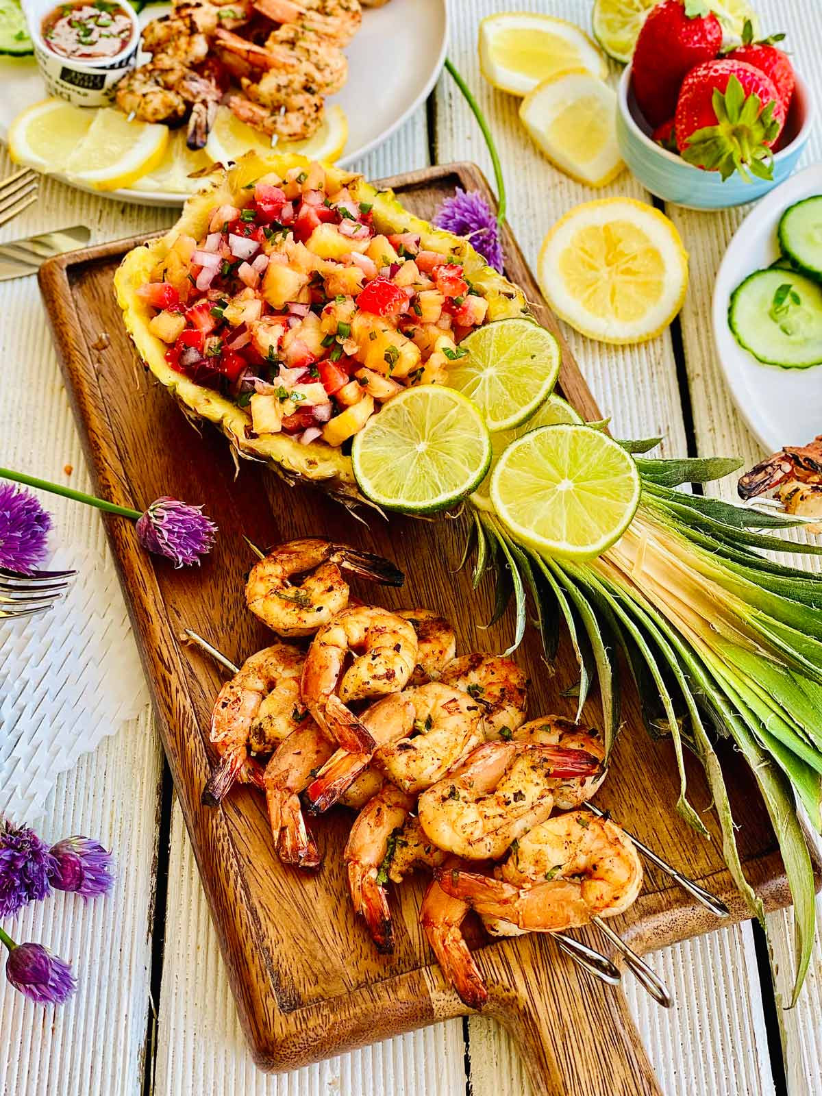 Pineapple mango salsa on a wooden board with grilled prawns next to it