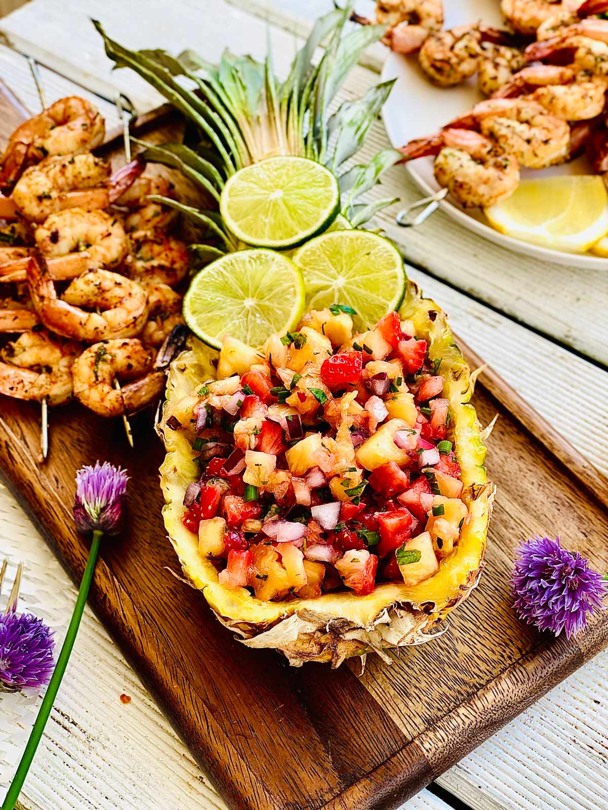 Pineapple mango salsa in a fresh pineapple boat topped with three lime slices