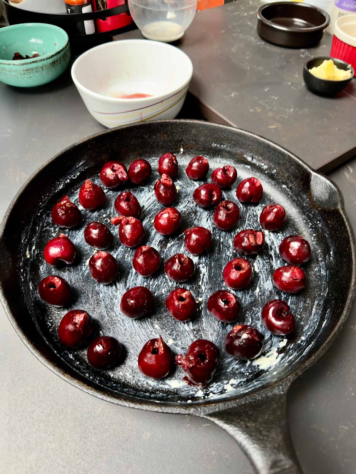 Pitted cherries arranged in greased cast iron pan.