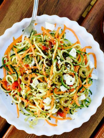 Vegetarian pesto courgette and carrot noodles with feta cheese and olives