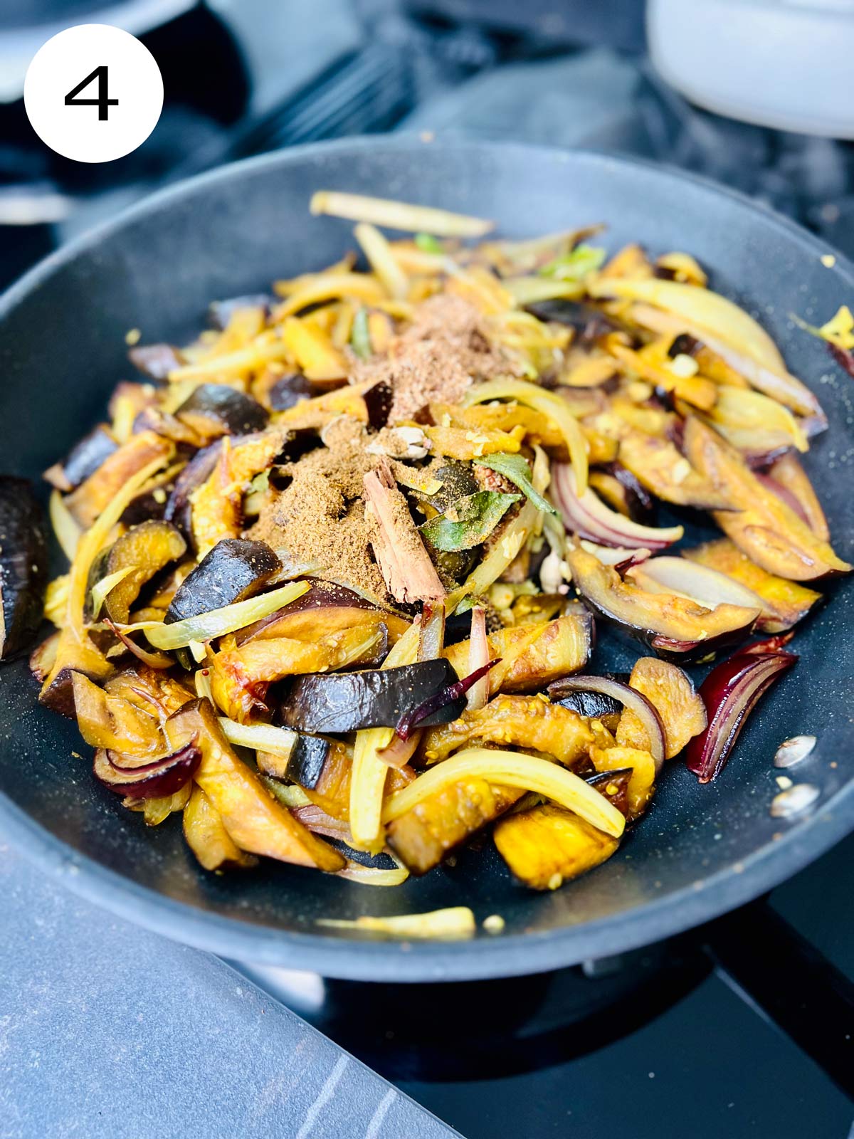 All spices, garlic and curry leaves added to the aubergine slices
