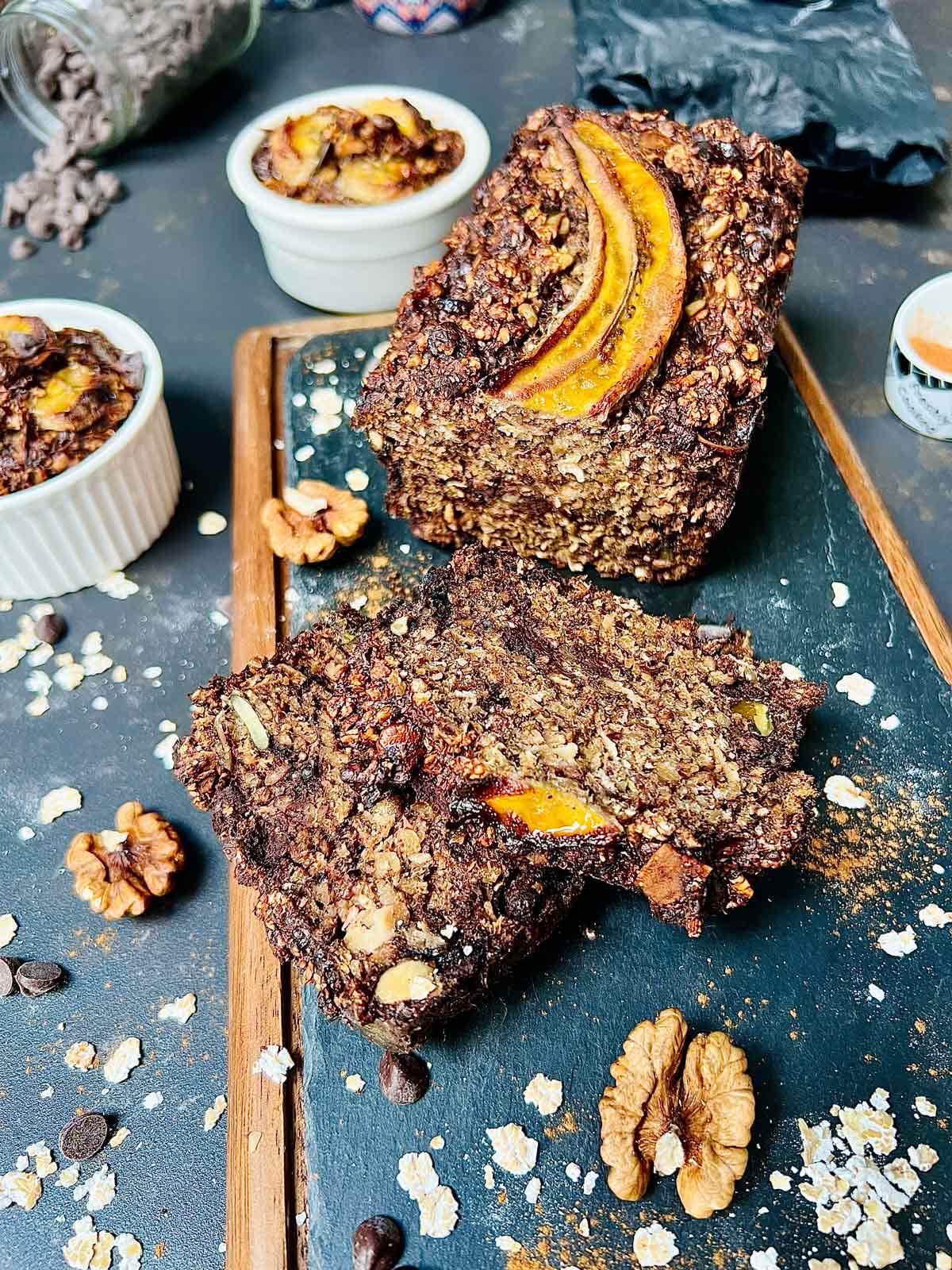 Banana loaf and two cut slices closeup on a nice presentation board.