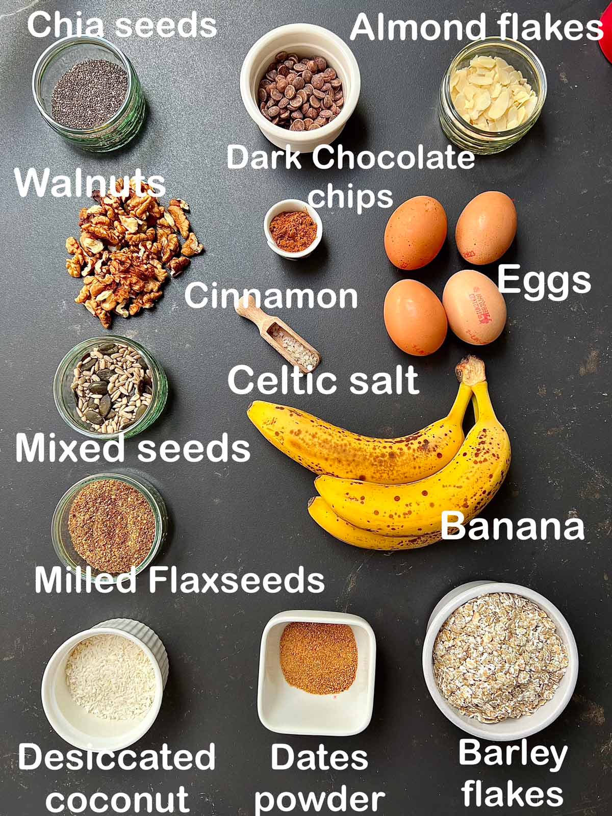 Ingredients needed for sugar-free banana loaf (Chia seeds, almond flakes, dark chocolate chips, walnuts, cinnamon, eggs mixed seeds, Celtic salt, flaxseeds, bananas com Barley flakes, dates powder, desiccated coconut).