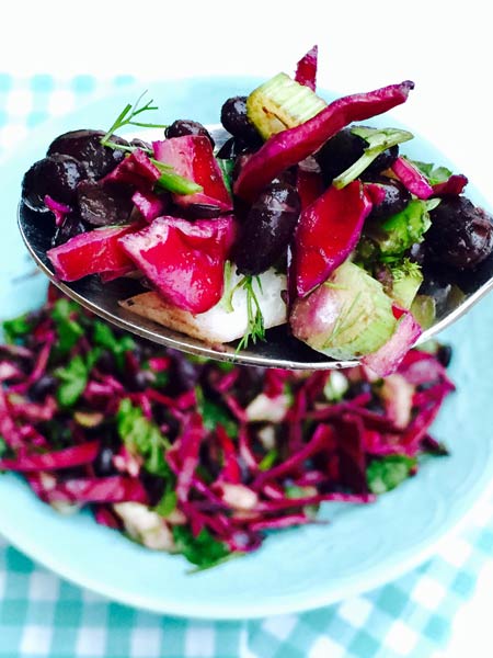 A spoon brimming with black beans, fennel and red cabbage, 100% organic.