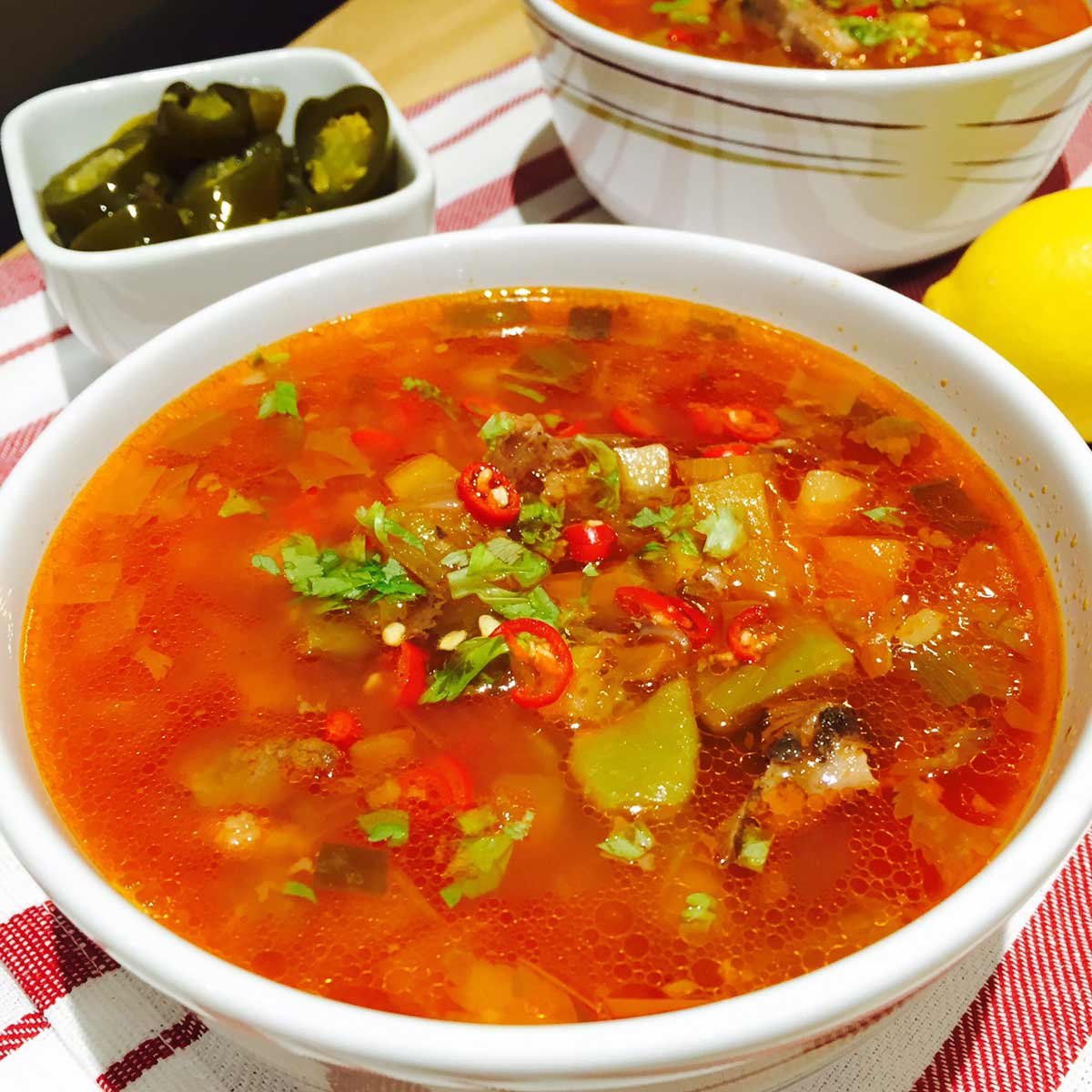 Soured beef broth in a white bowl