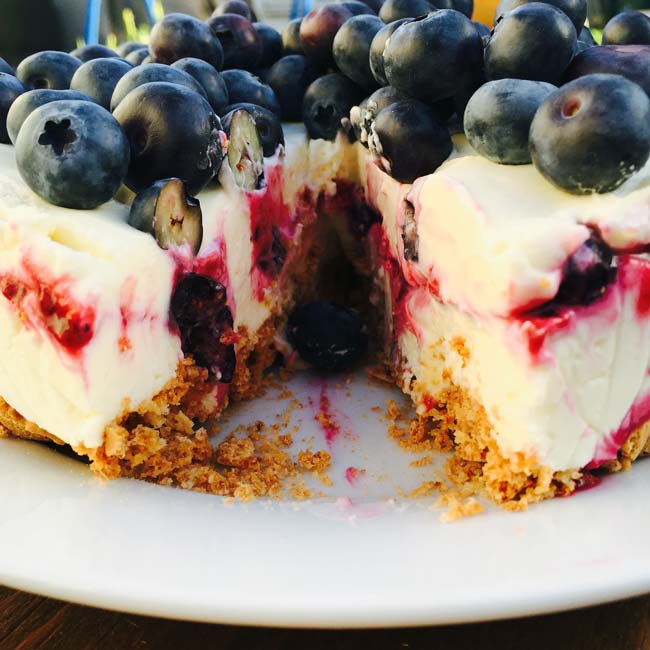 A cheese cake with berries & amaretti, sliced