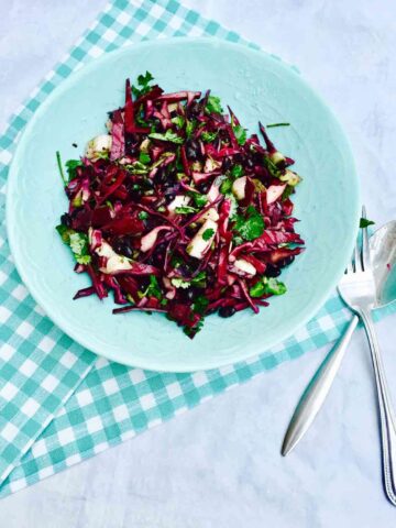 A blue plate with scrumptious black beans, fennel and red cabbage salad, all organic.
