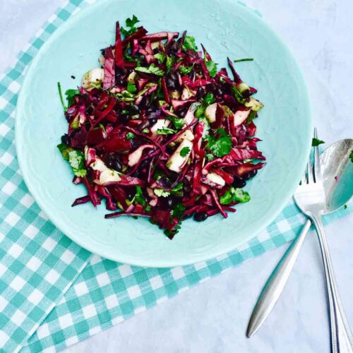 A blue plate with scrumptious black beans, fennel and red cabbage salad, all organic.