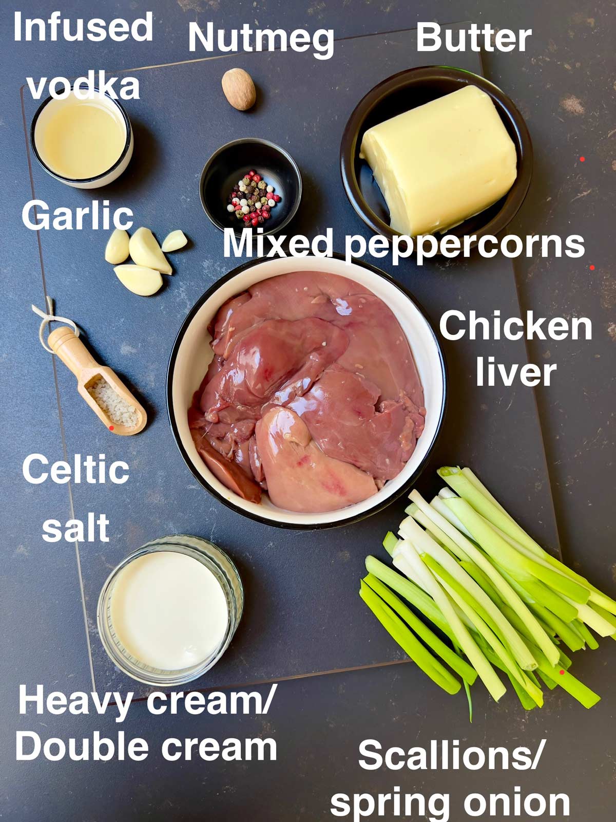 All the ingredients that are needed for chicken liver parfait: chicken liver, butter, nutmeg, vodka, garlic, mixed peppercorns, spring onion/scallions, Celtic salt, Heavy cream/double cream.