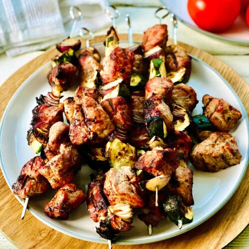 Chicken skewers in the oven on a white plate