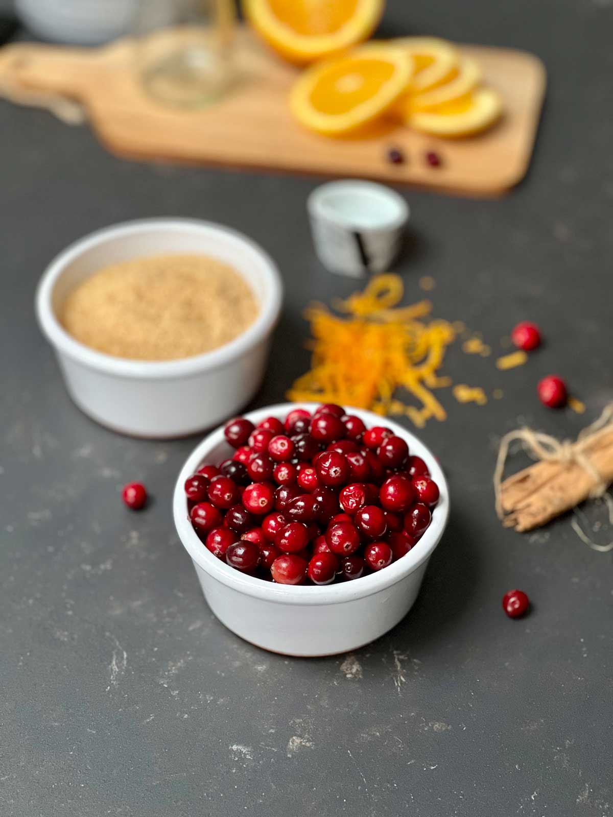 Cranberries in a white bowl and the remaining ingredients in the background.