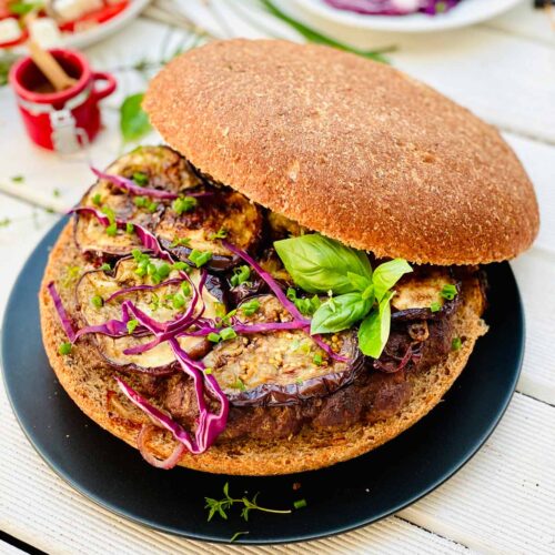 Giant Lamb Burger with Miso Aubergines on a Black Plate