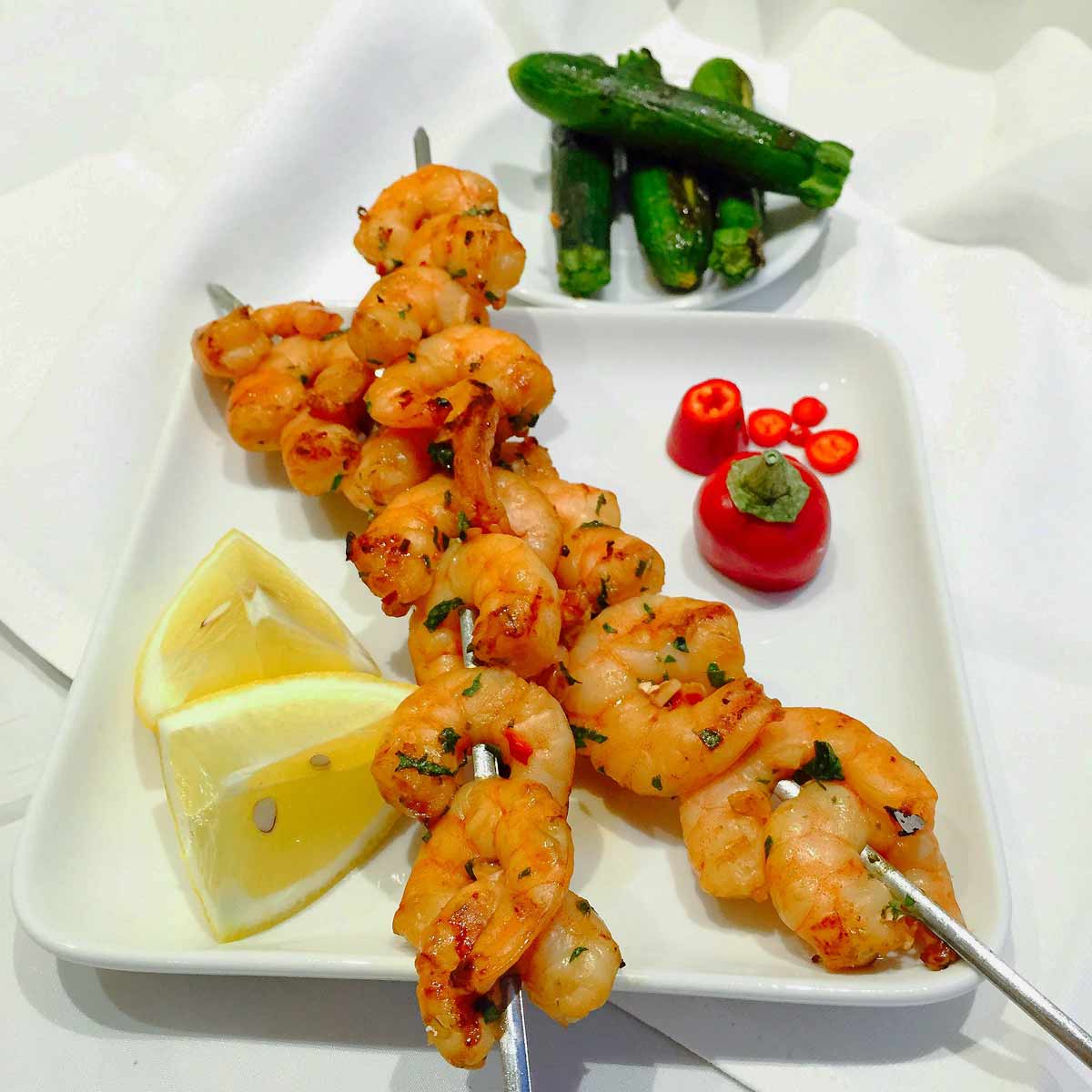 Two skewers of barbecued prawns