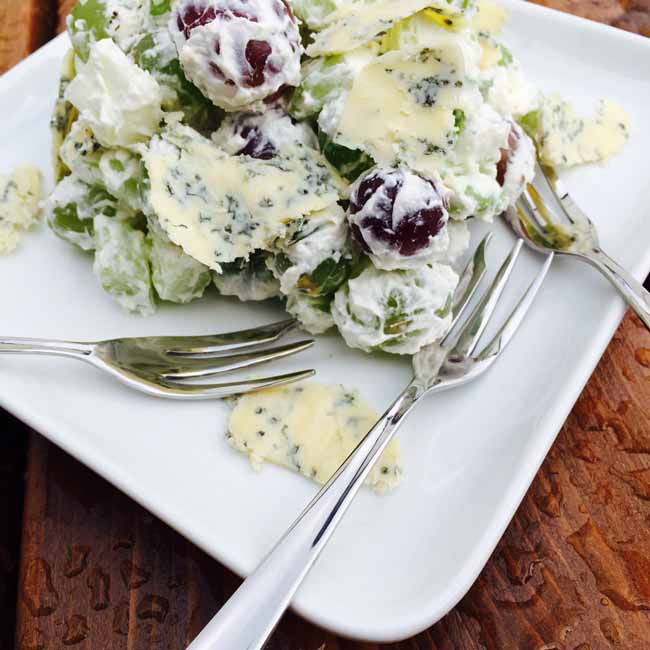 A plate with grapes & cheese salad chunks