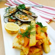 Greenshell mussels with homemade chips, on a white plate