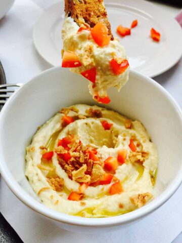 A white bowl of excellent homemade hummus.