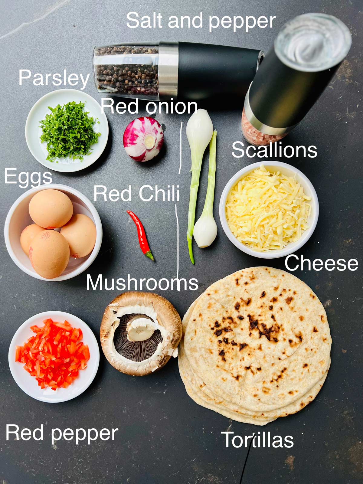 Ingredients needed for egg and tortilla, fresh parsley, red onion, red Chili, eggs, scallions, salt and pepper, cheese, mushroom, tortillas.