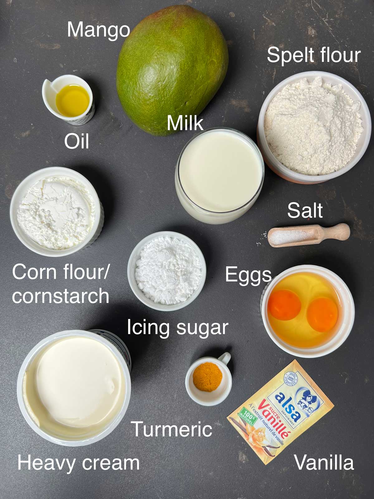 Ingredients needed for mango, pancakes, oil, mango, spelt flour, milk, salt, eggs, icing, sugar, cornflour/cornstarch, vanilla, turmeric and heavy cream.