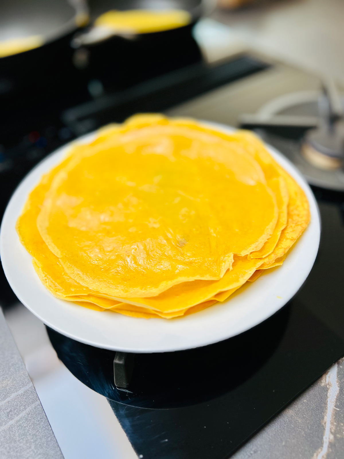 A stack of mango pancakes on a white ceramic plate.