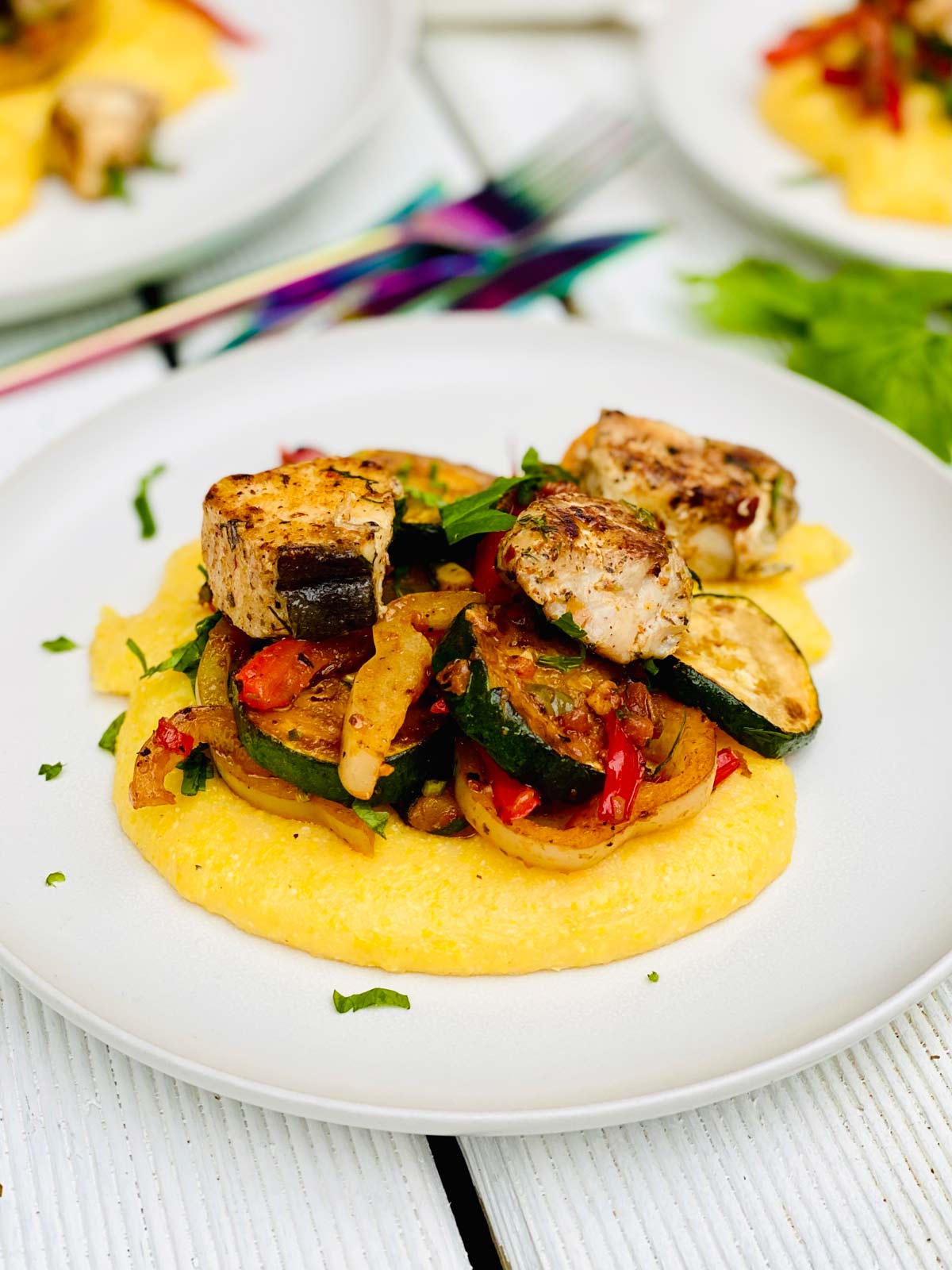 Halibut chunks with chopped parsley sprinkled over, on top of polenta