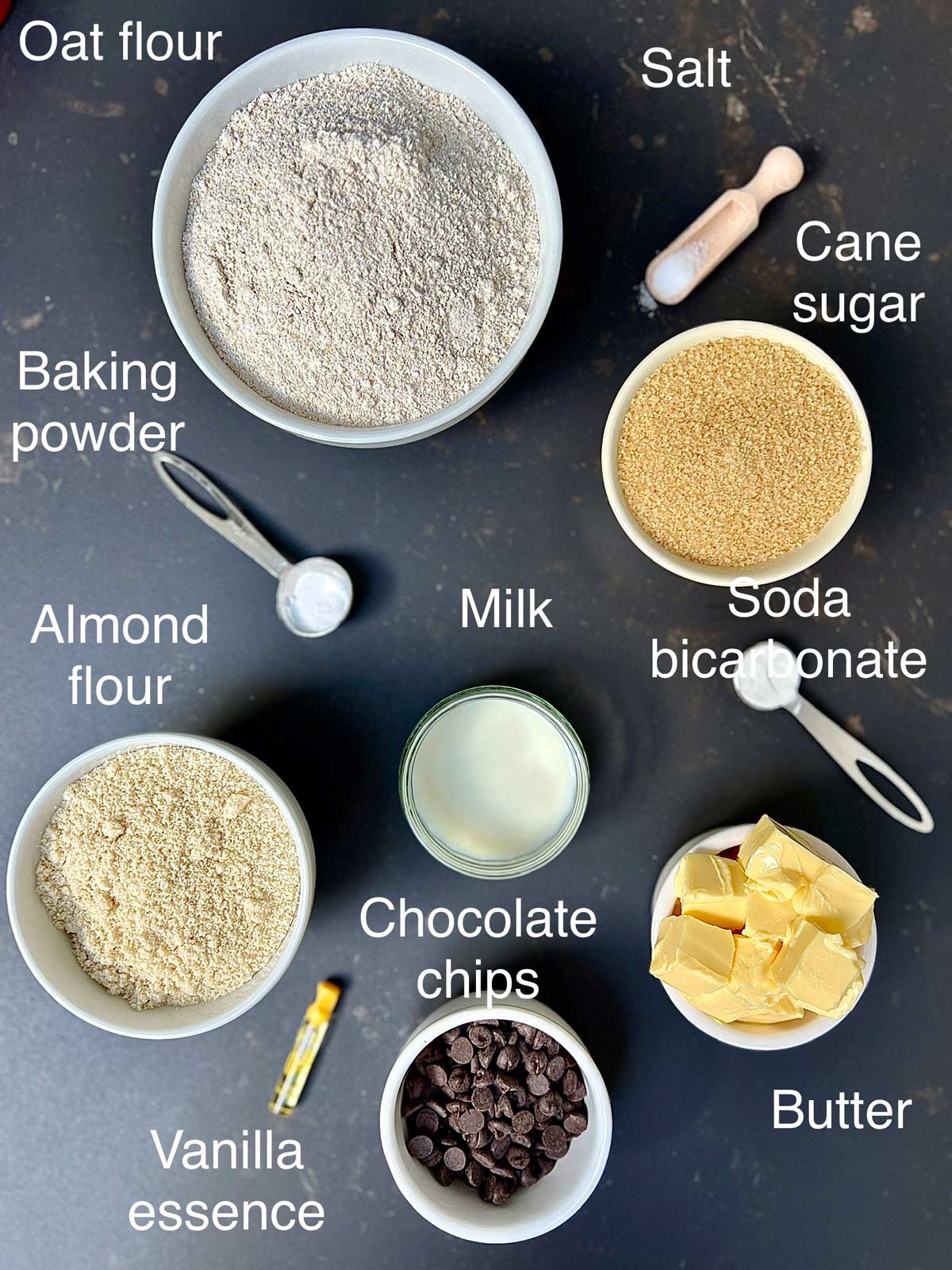 Ingredients needed for oat flour cookies (milk, chocolate chips , oat flour, almond flour, cane sugar, baking powder, soda bicarbonate, softened butter, salt and vanillla).