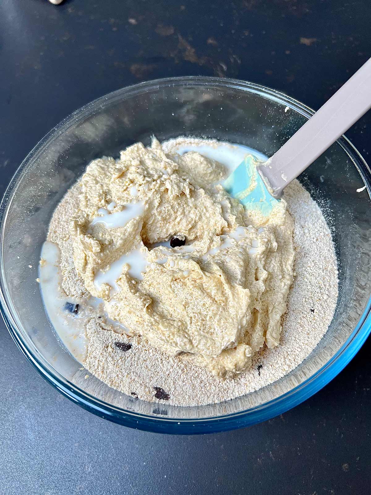 All ingredients added to a glass bowl to make the oat flour cookies batter.