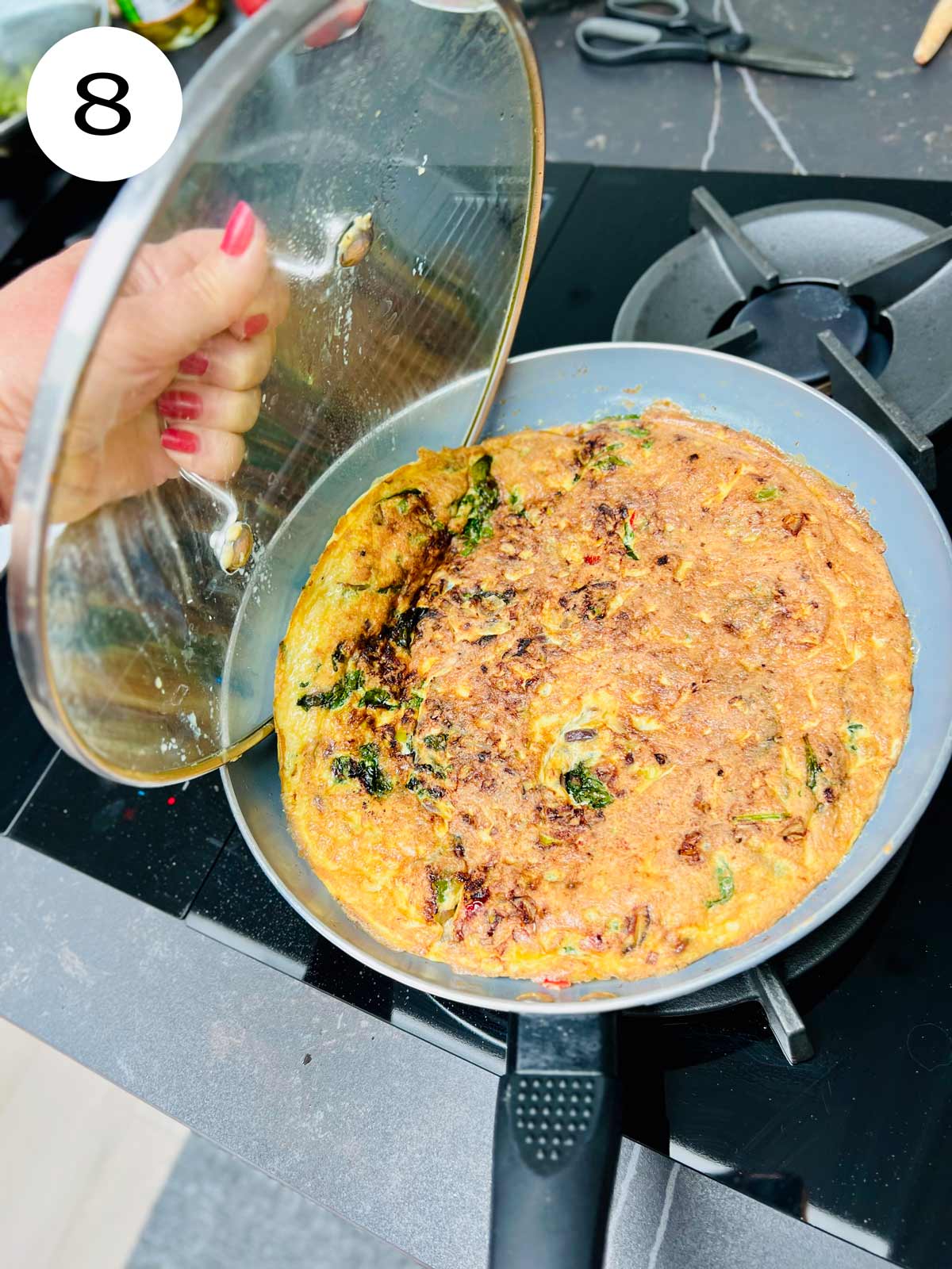 Omelette being slid back in the pan from the lid.