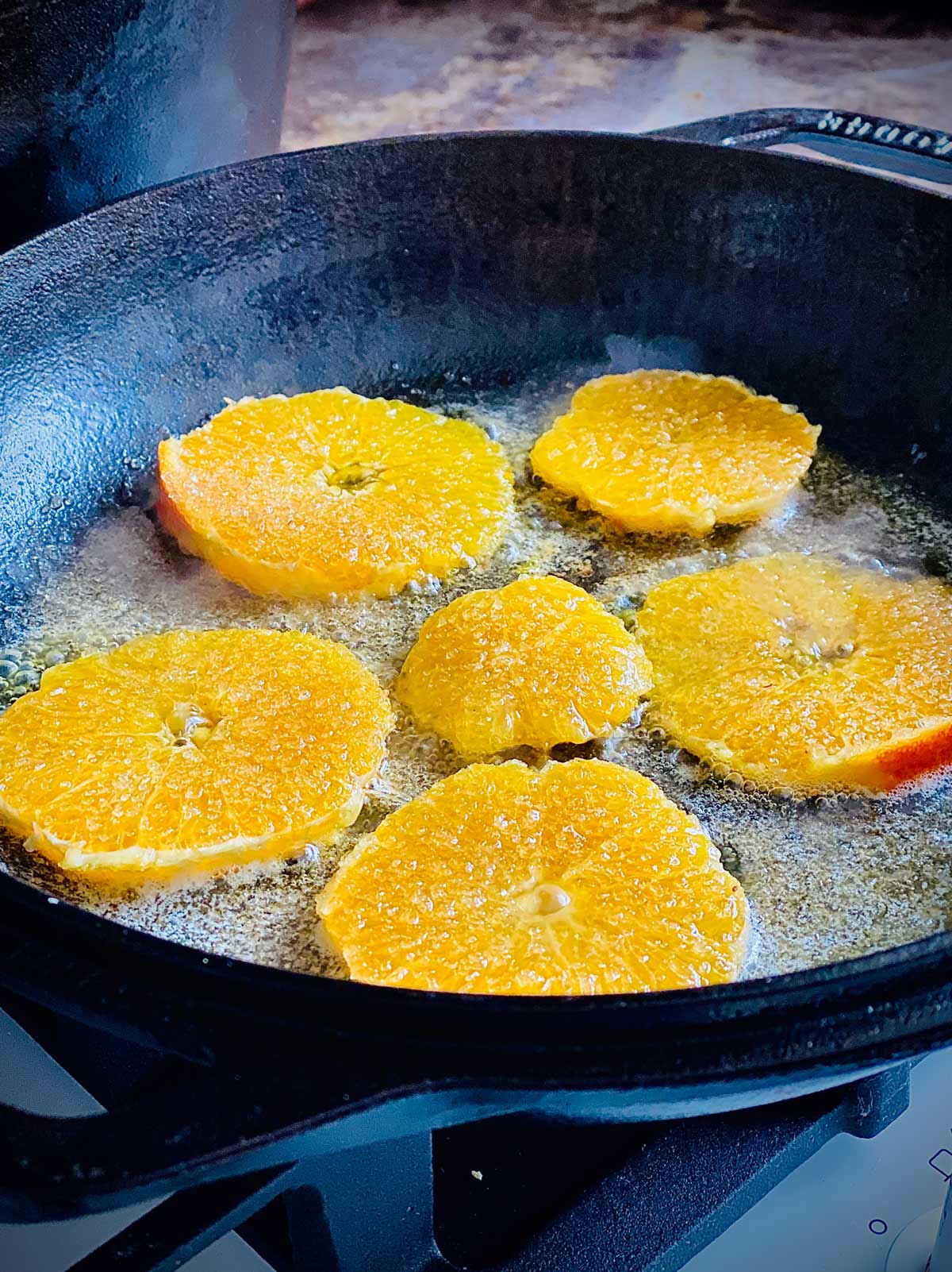 Orange slice cooking in butter for dutch baby pancakes