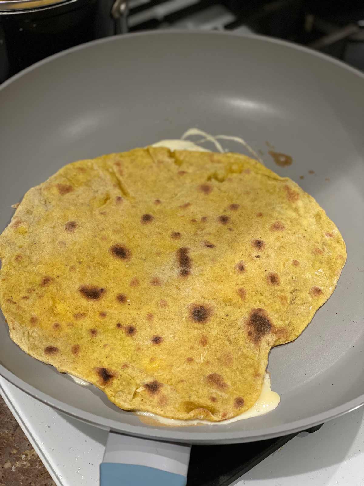 paratha lined with egg in a gray pan for the chicken egg roll recipe