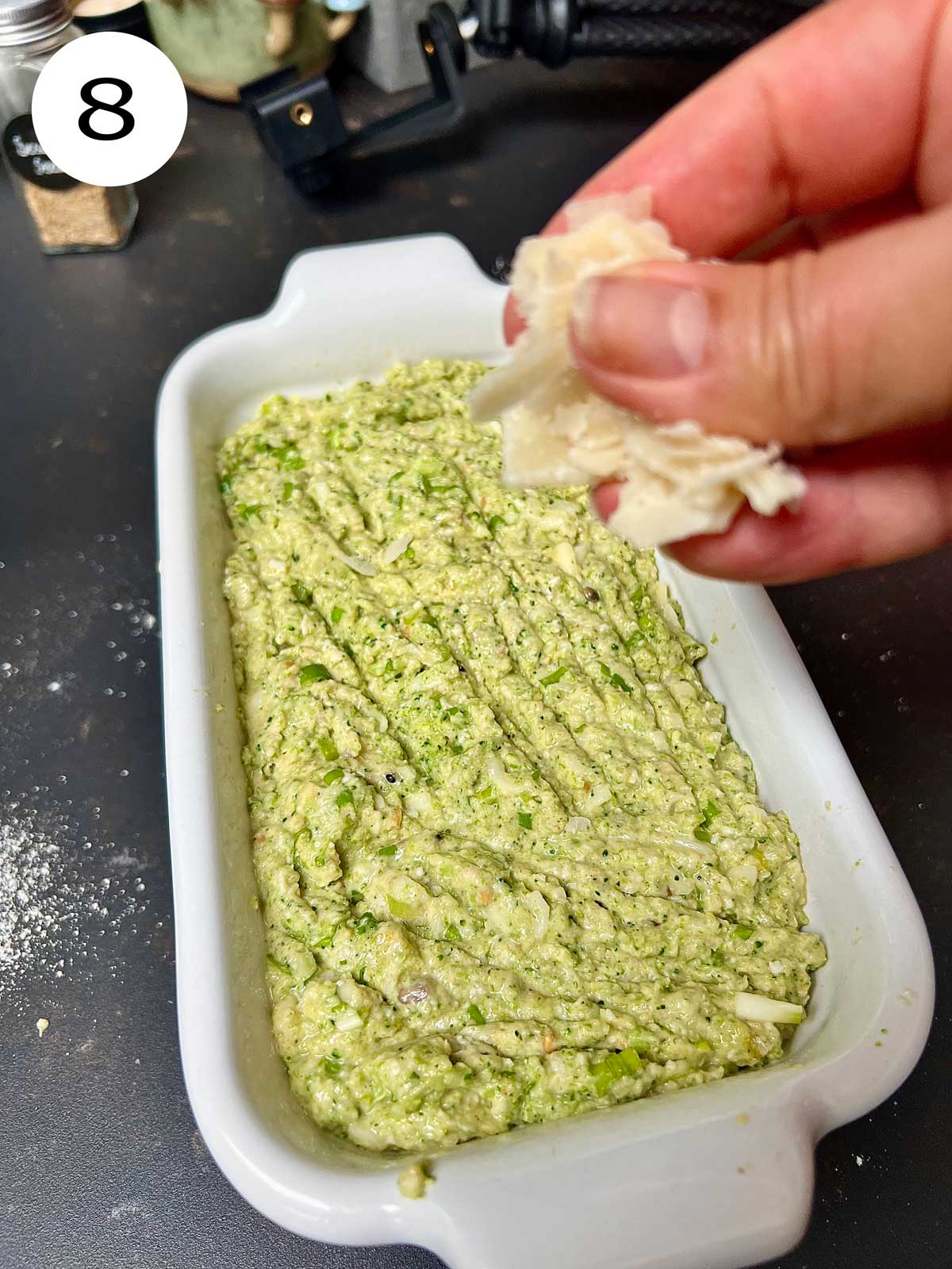 Sprinkling some Parmesan cheese over the broccoli bread just before going into the oven.