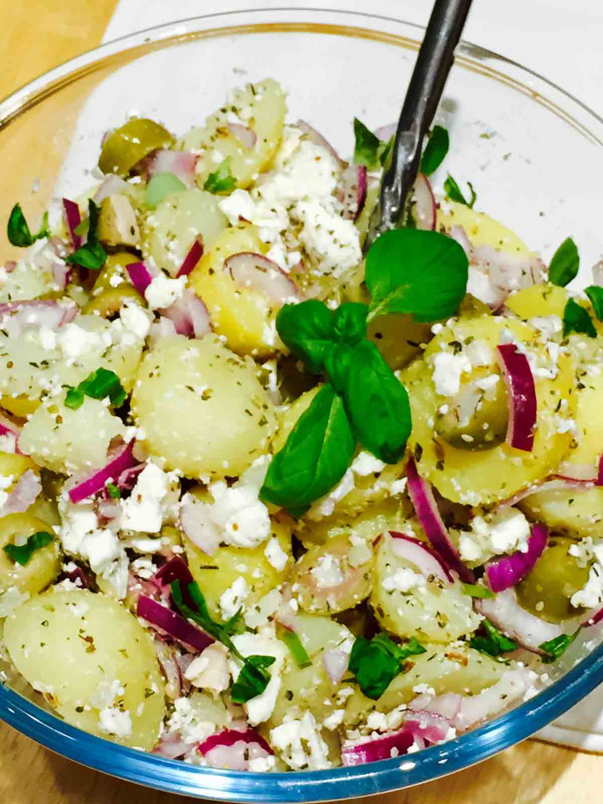 A bowl full of delicious potato, olives and feta cheese salad.