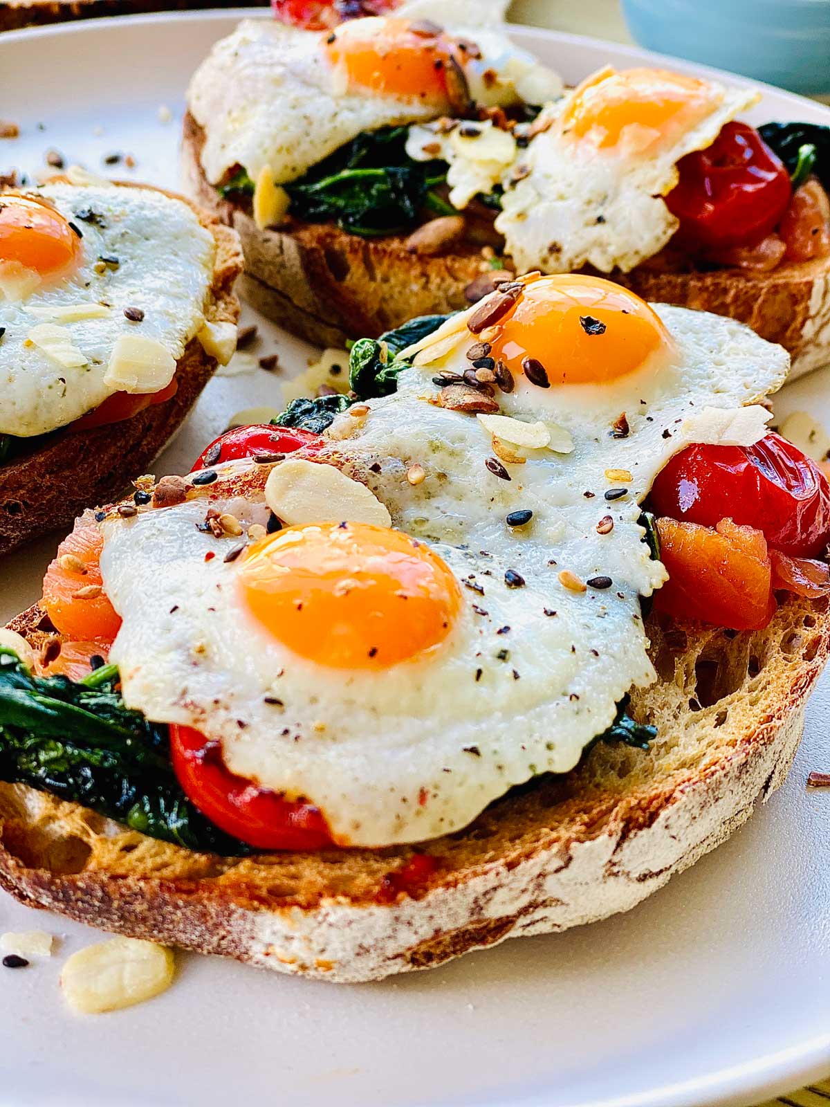 Quail eggs open sandwich with salmon, spinach and cherry tomatoes.