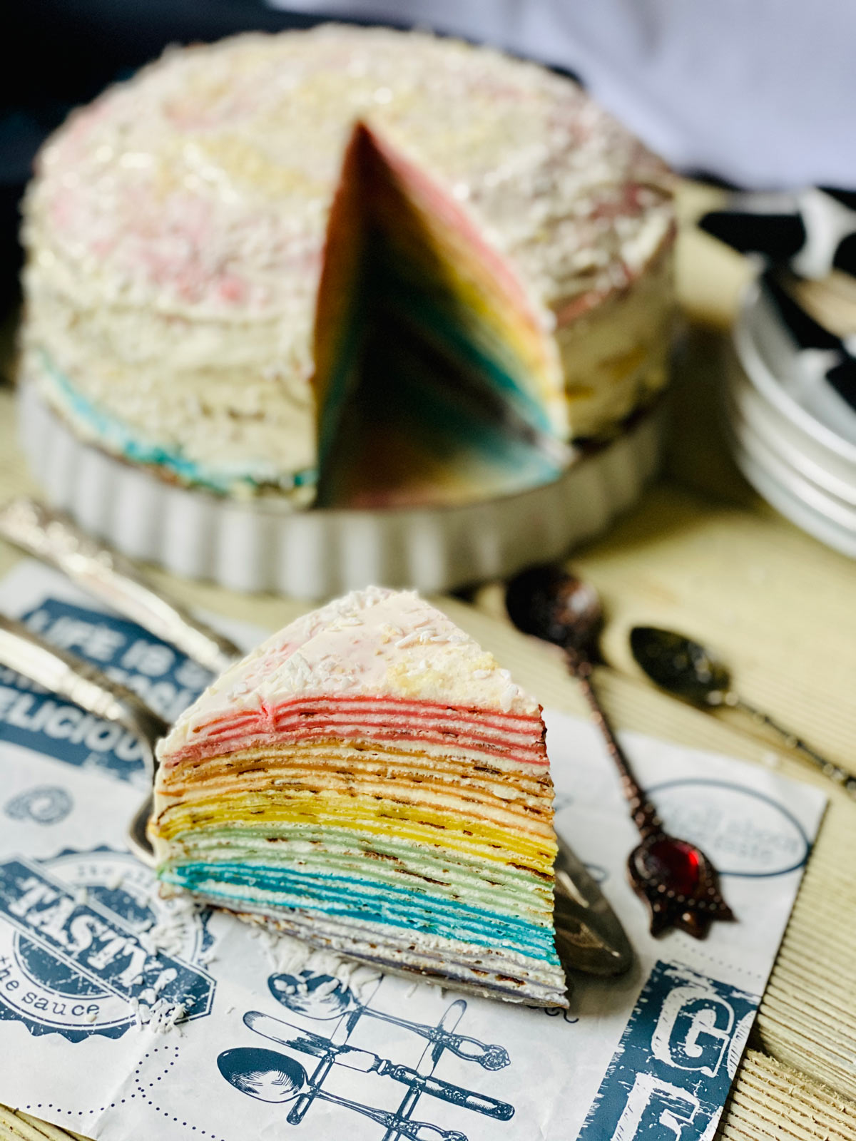 Rainbow crepe cake slice close up on patterned paper