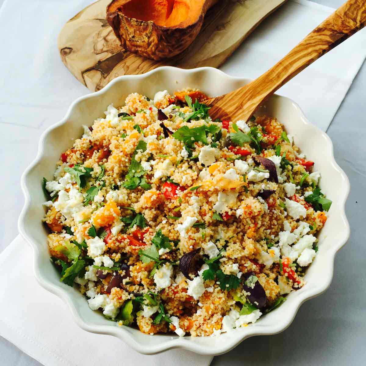 A white bowl with roasted veggies & feta couscous