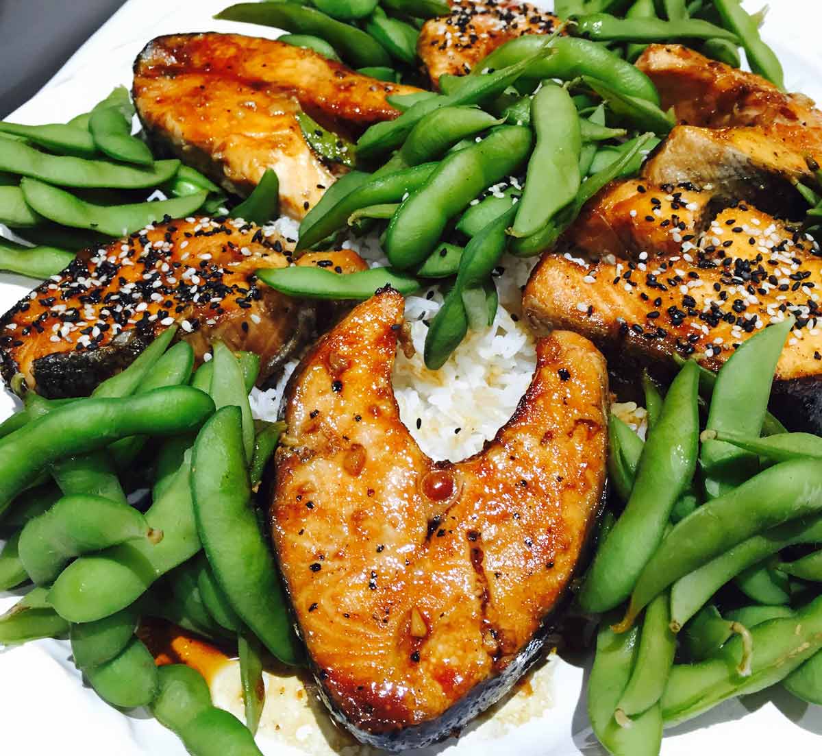 Salmon teriyaki with edamame and rice, on a white plate