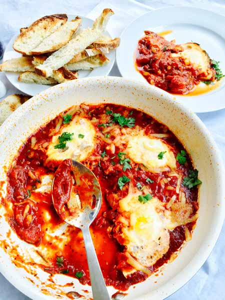 A white plate with shakshuka, all ready to go.