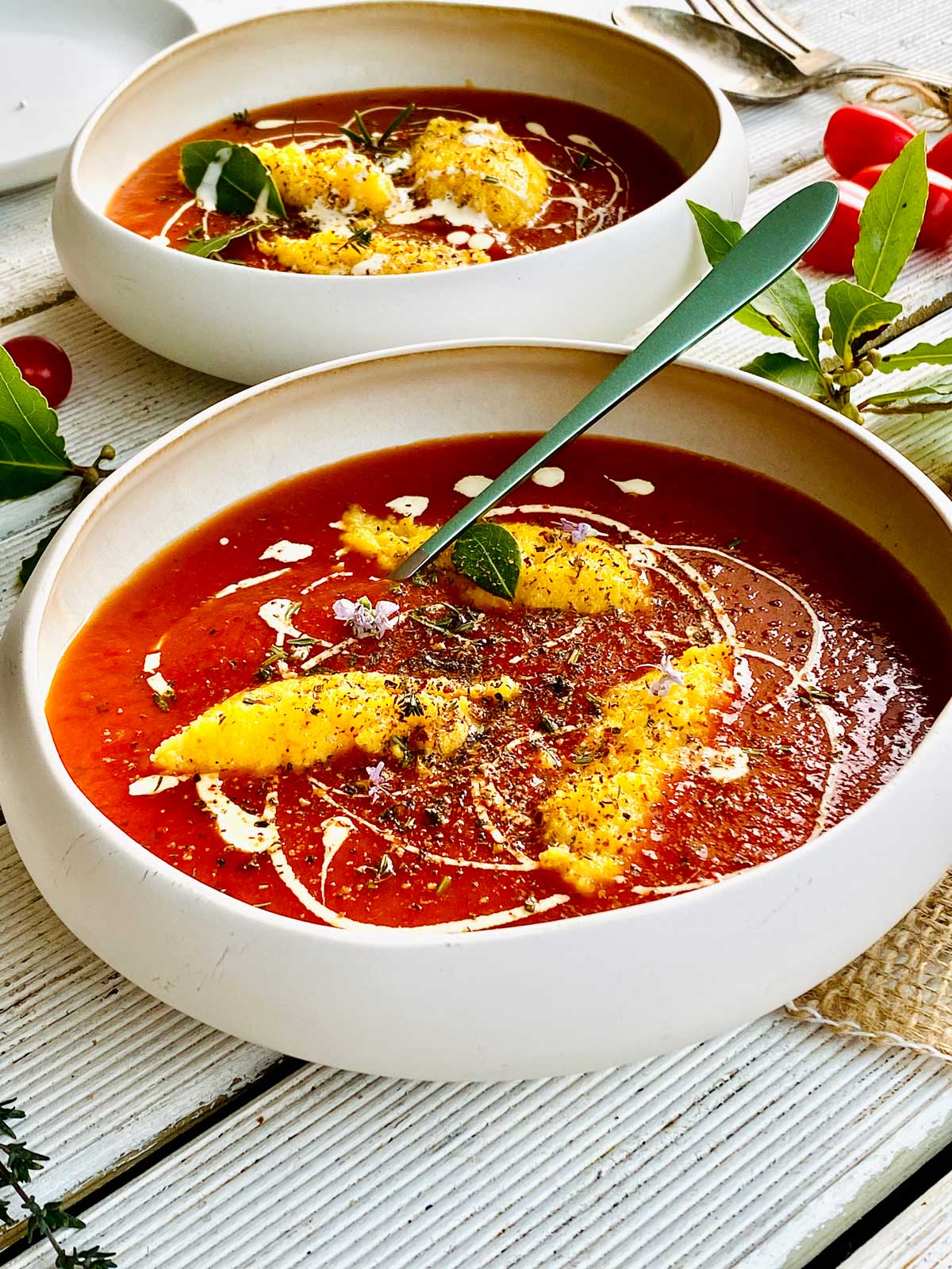 Two bowls with tomato and polenta dumplings soup