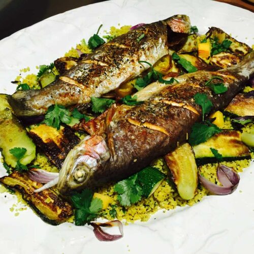 Trout with courgette and cauliflower couscous, on a white plate