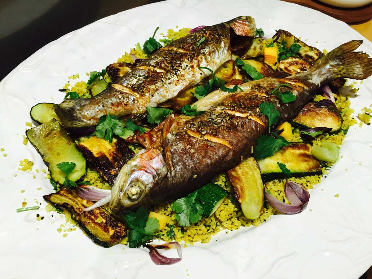 Trout with courgette and cauliflower couscous, on a white plate