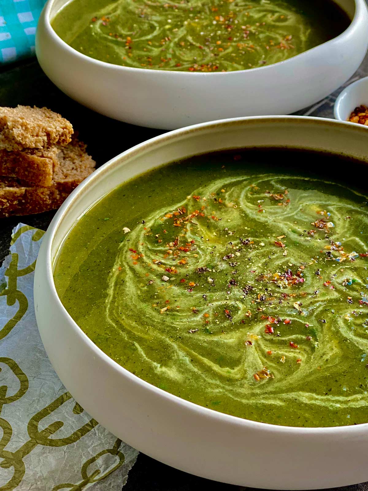 Two soup bowls containing nettle soup and freshly foraged wild garlic